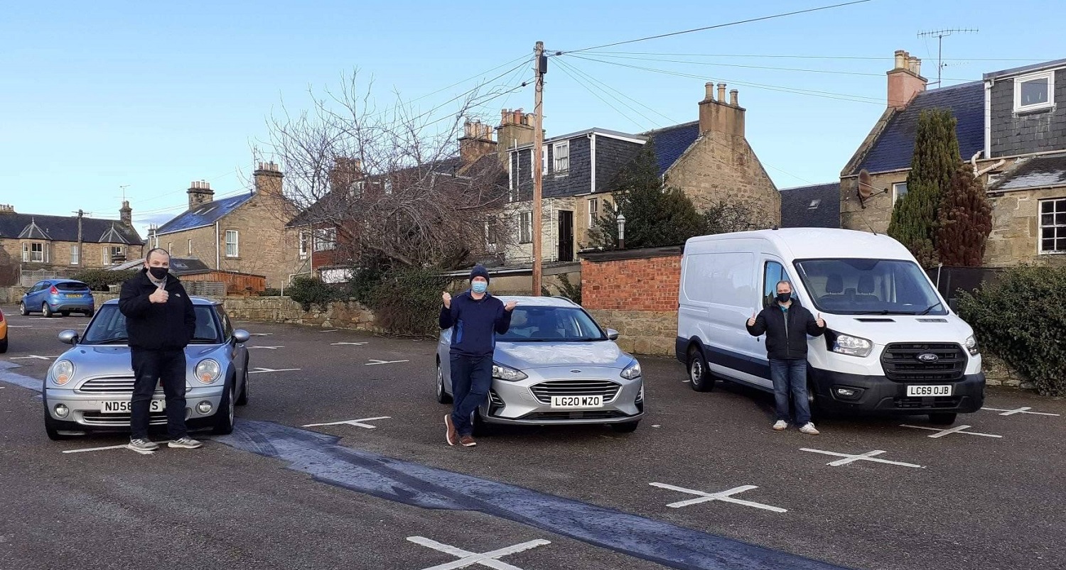 Martyn Woodward, Hospitality lecturer and colleagues standing beside vehicles to deliver working from home packs to students