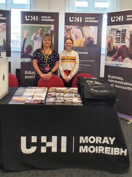 Photo of Siobhan, our career ready intern in 2022, and Jacqui Taylor, Head of Marketing an External Relations, standing at a stall at the RAF Adult Learners Day