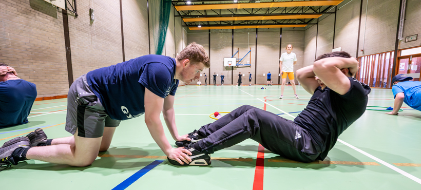 student helping student do sit ups