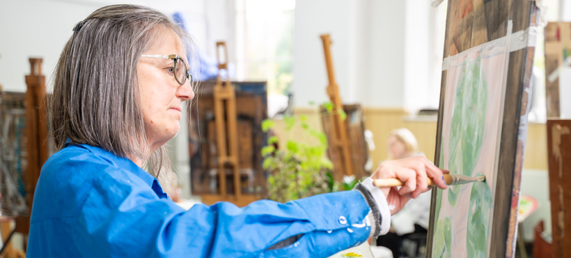 student painting on an easel