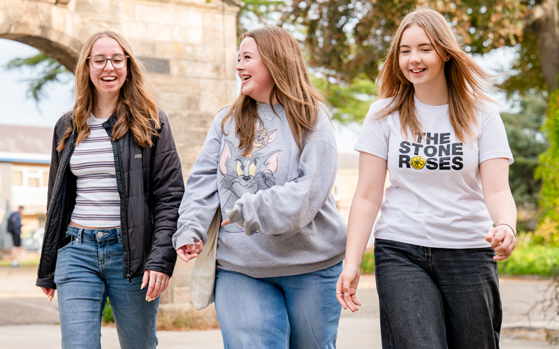 3 students walking outside