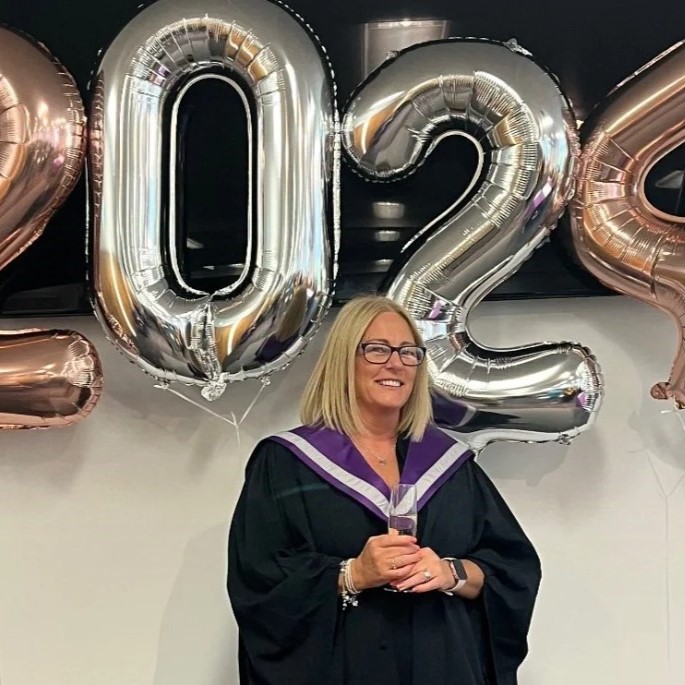 Photograph of Lyndsey Monkhouse, a UHI Moray graduate. She is stood in front of Photograph of Lyndsey Monkhouse, a UHI Moray graduate. She is stood in front of