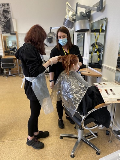 Lori Duffus, Hairdressing graduate and lecturer, teaching students in HBCT Salon