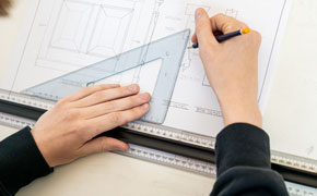 Close up of a construction students hands drawing plans