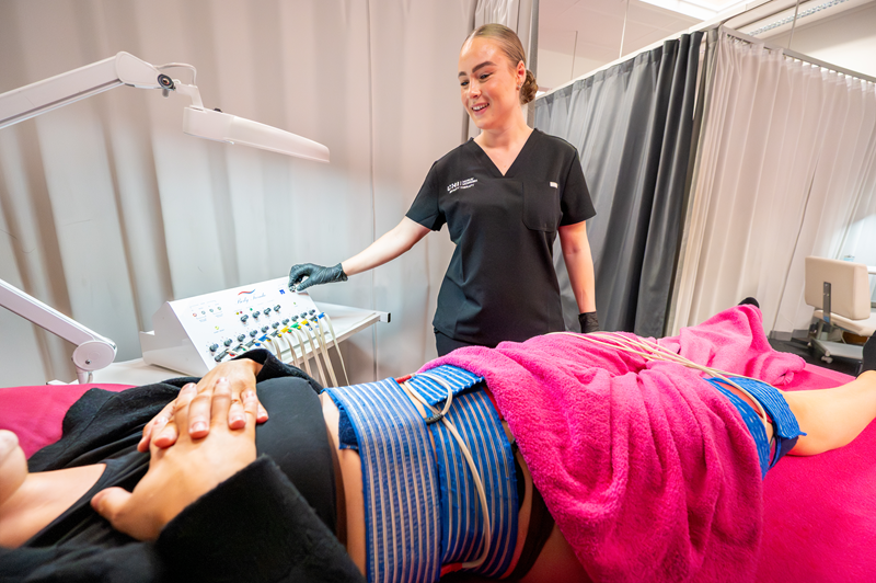 Photo of a beauty student doing an electrotherapy session with a client Photo of a beauty student doing an electrotherapy session with a client
