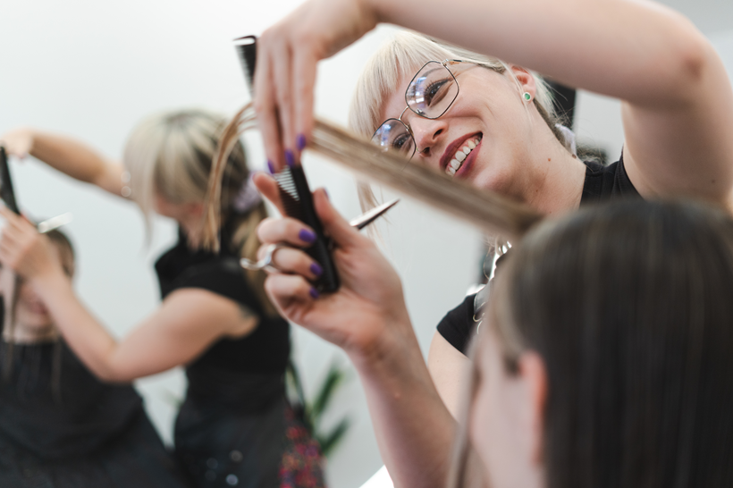 Photo of a female hairdresser cutting a clients hair in a salon Photo of a female hairdresser cutting a clients hair in a salon