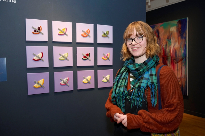 Codie Anne standing in front of artwork